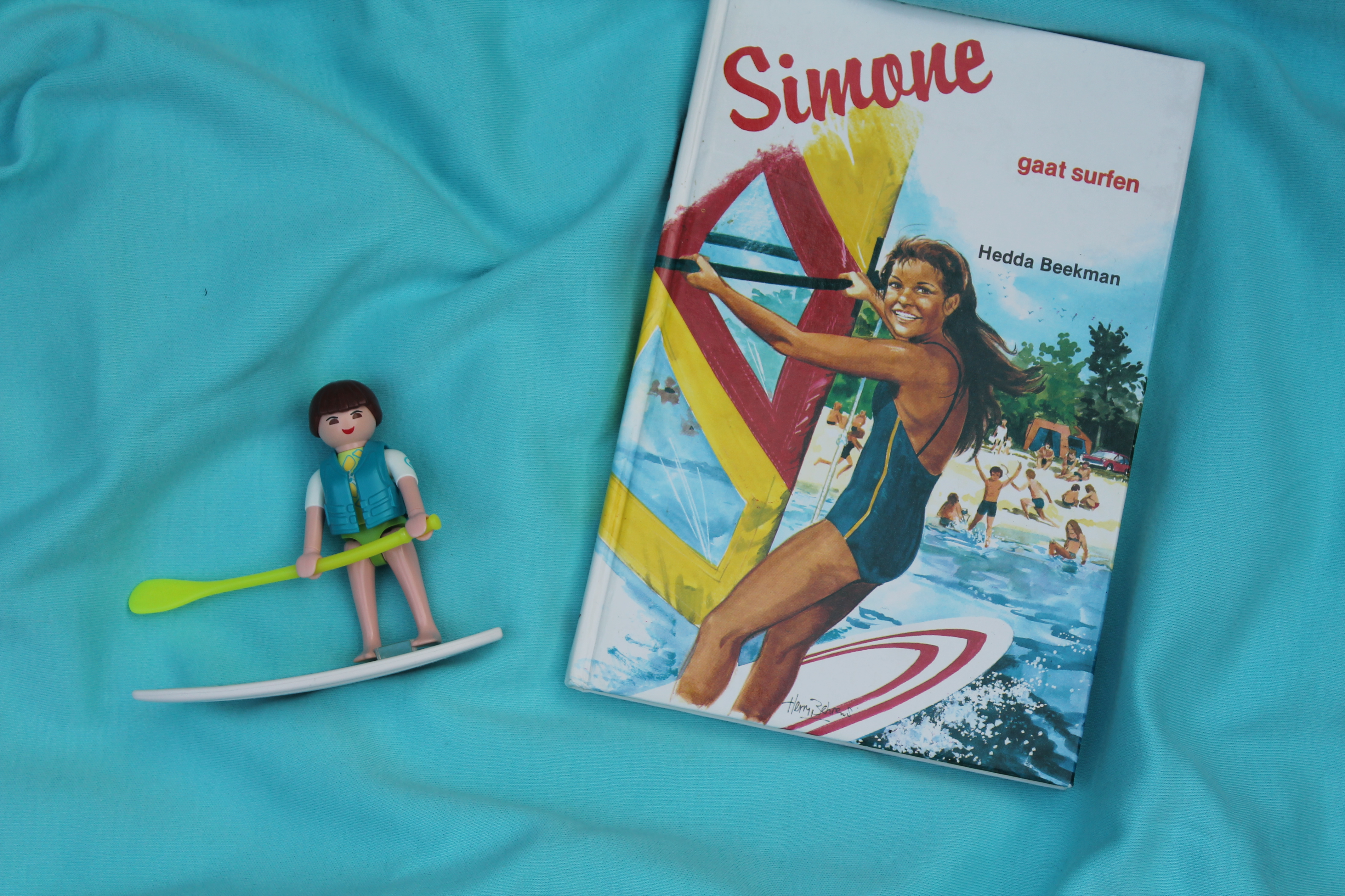 Boek, meisje op surfplank, blauwe zee